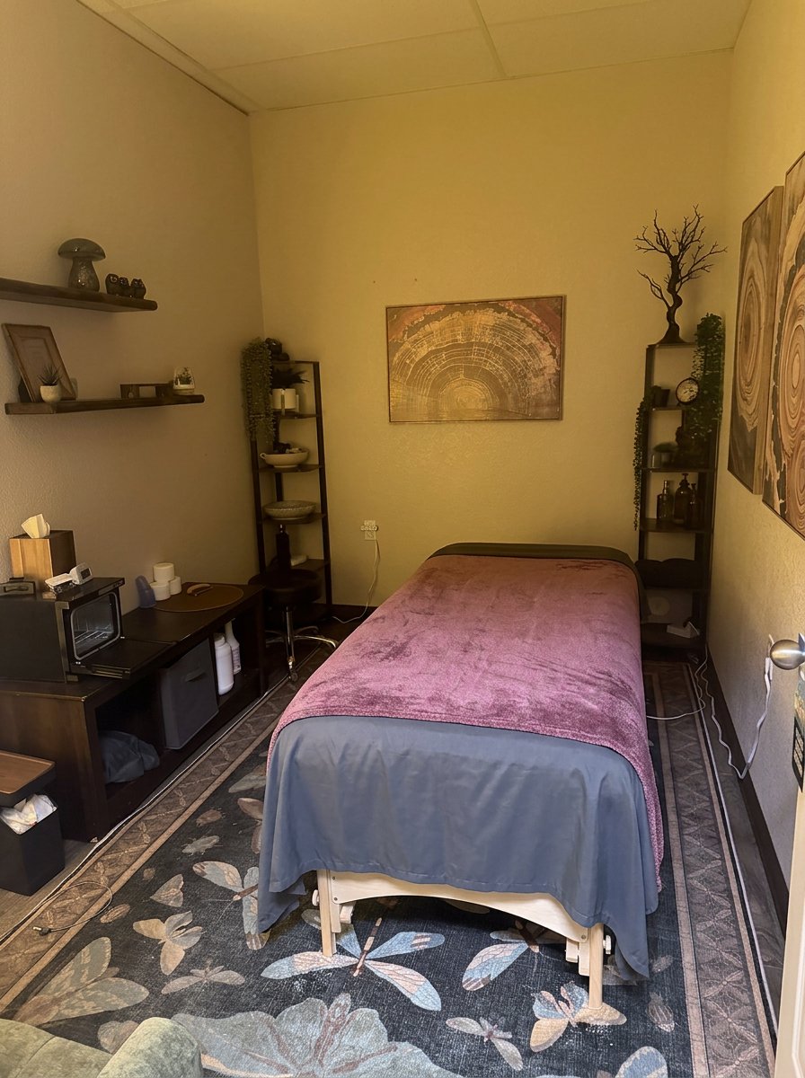 Rachel’s massage table with shelves and artwork, viewed from the doorway