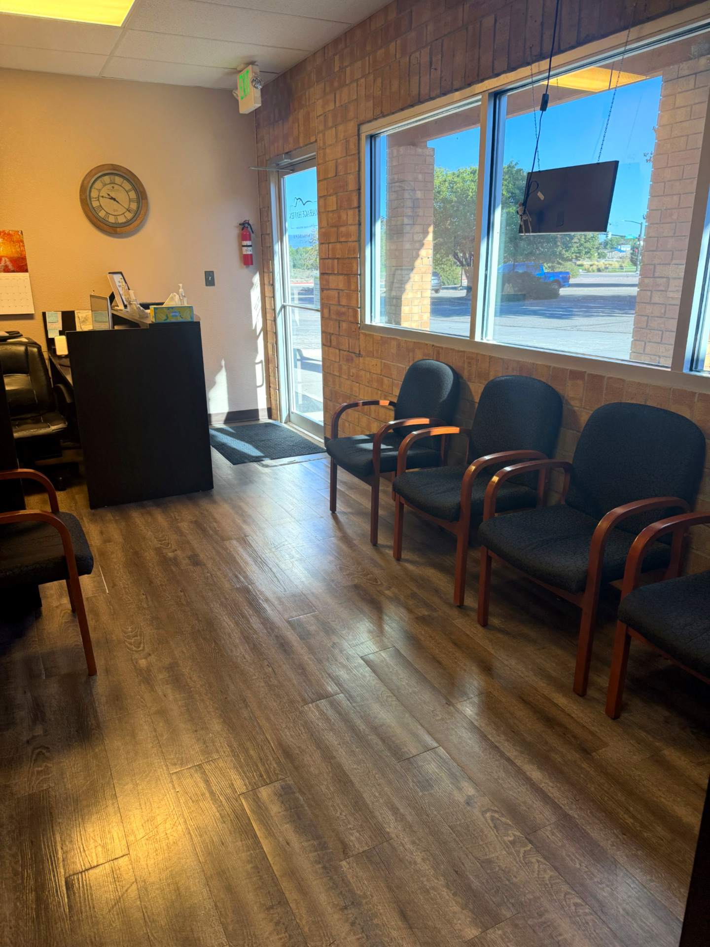 Massage Haven's sunlit lobby with seating beside the brick wall