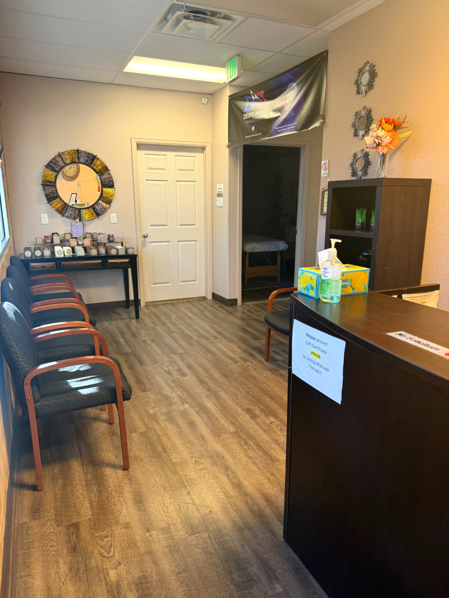 Massage Haven's reception desk with seating, a round mirror, and the soap display